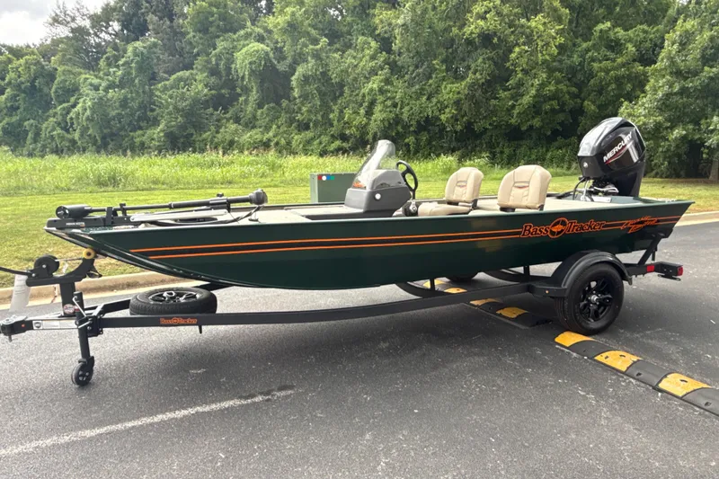 The Image of 2026 Tracker Bass Tracker Classic Limited boat on trailer, parked near lush greenery. - 0
