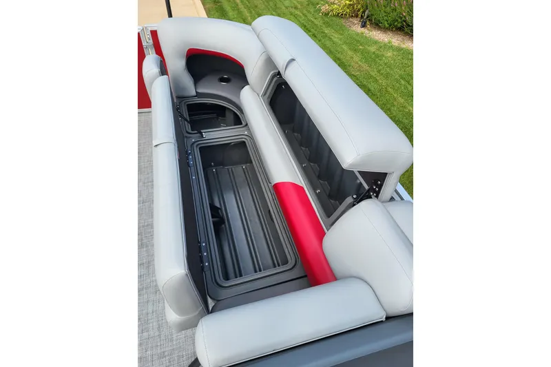 Slide: The Image of 2026 Sun Tracker Party Barge 20 DLX seating with storage compartments, gray and red upholstery. - 7