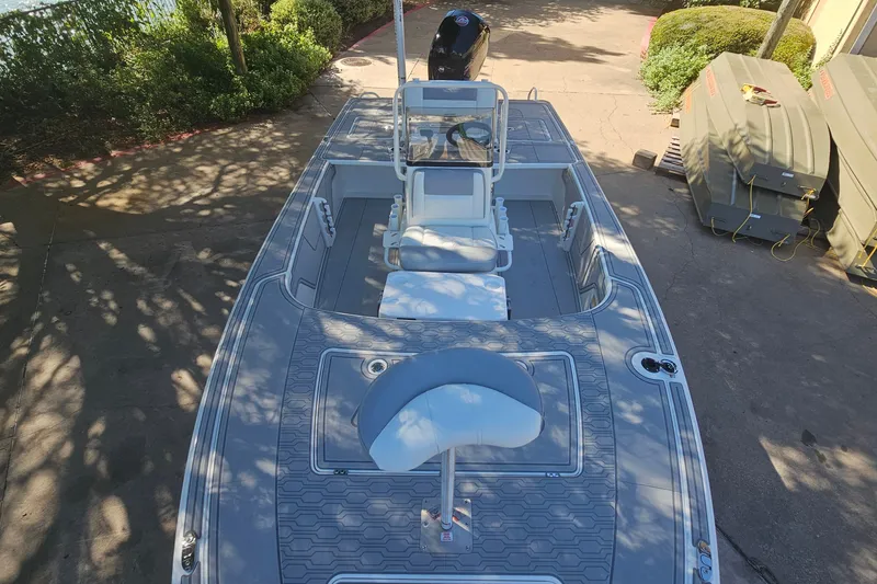 Slide: The Image of 2026 Mako 18 Pro Skiff boat, top view, parked outdoors, showcasing spacious deck layout. - 9