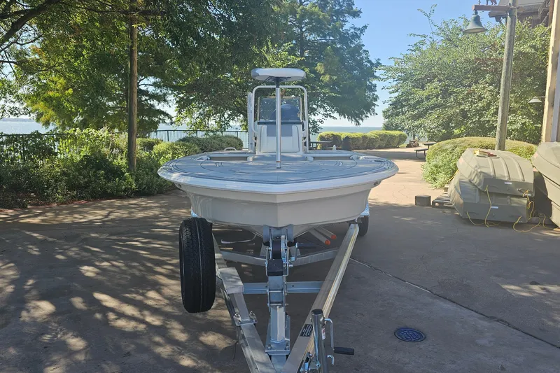 Slide: The Image of 2026 Mako 18 Pro Skiff on trailer, parked outdoors near lush greenery. - 62