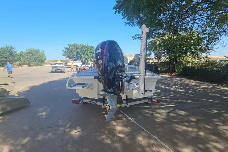 Slide: The Image of 2026 Mako 18 Pro Skiff boat on trailer, parked outdoors under clear blue sky. - 5