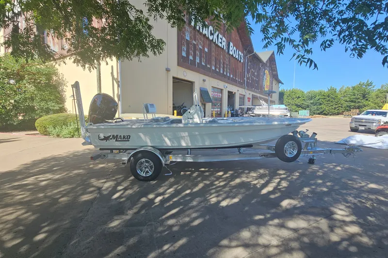 Slide: The Image of 2026 Mako 18 Pro Skiff boat on trailer outside Tracker Boats store. - 3