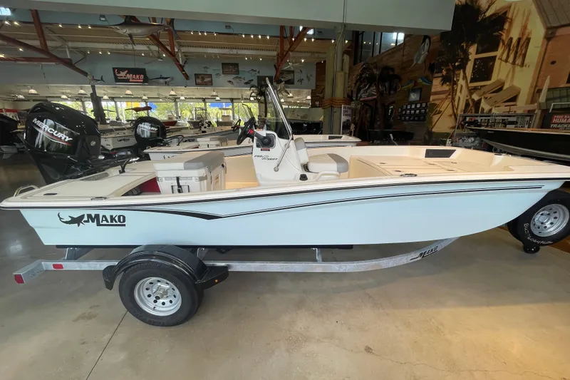 Slide: The Image of 2026 Mako Pro Skiff 15 CC boat displayed in a showroom on a trailer. - 1