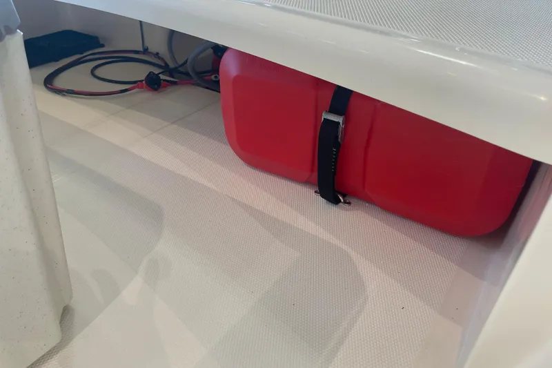 Slide: The Image of Red fuel tank secured in a 2026 Mako Pro Skiff 15 CC boat compartment. - 10