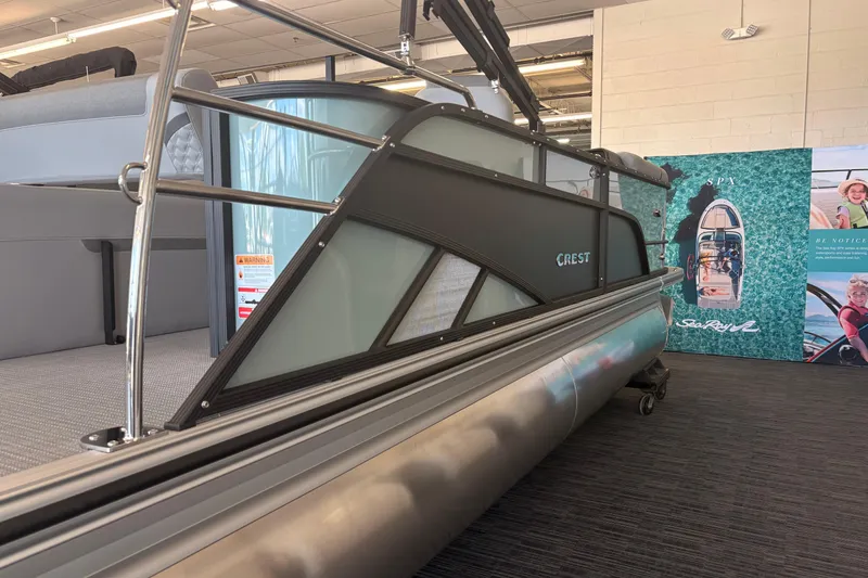 The Image of 2026 Crest Conquest 230 SLSC pontoon boat displayed indoors with promotional banner. - 1