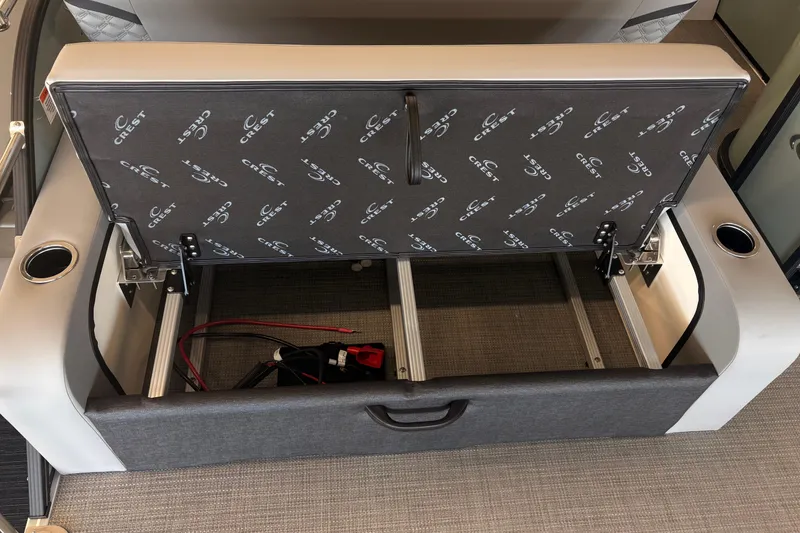 Slide: The Image of Open storage compartment in 2026 Crest Conquest 230 SLSC boat seat, showcasing interior space. - 16