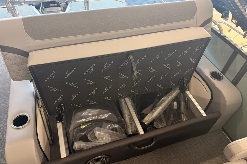 Slide: The Image of Storage compartment of 2026 Crest Conquest 230 SLSC boat with open seat revealing contents. - 17