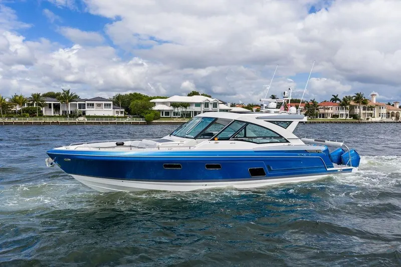 Slide: The Image of 2023 Formula 430 Super Sport Crossover cruising on a scenic waterfront. - 1