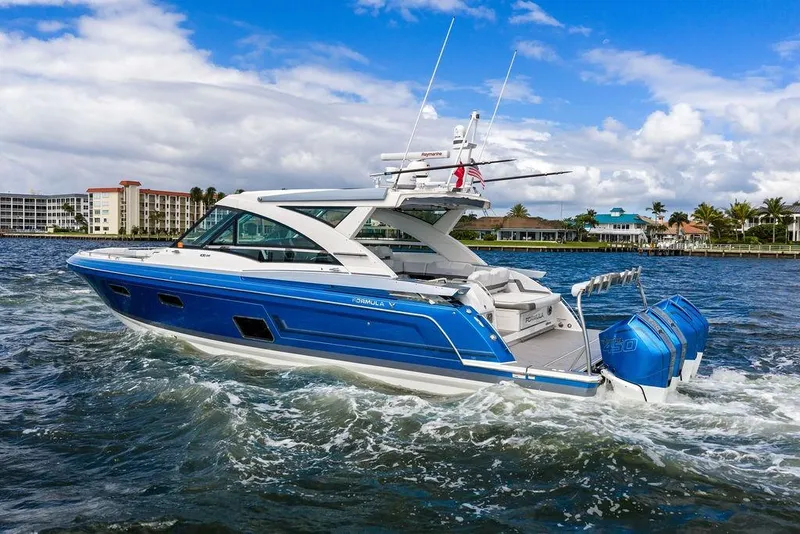 Slide: The Image of 2023 Formula 430 Super Sport Crossover cruising on a scenic waterway. - 2