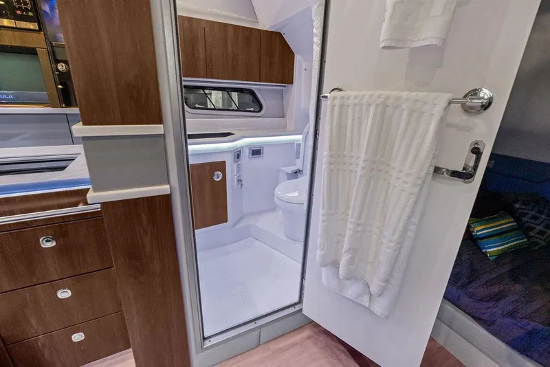 Slide: The Image of Interior of 2023 Formula 430 Super Sport Crossover, featuring a modern bathroom and wooden cabinetry. - 21