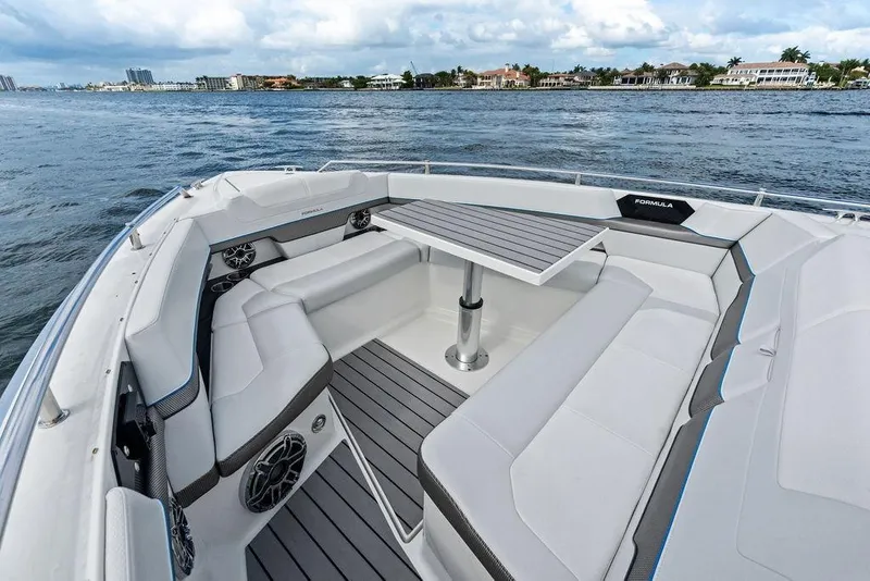 Slide: The Image of 2023 Formula 430 Super Sport Crossover boat interior with seating and table on water. - 23