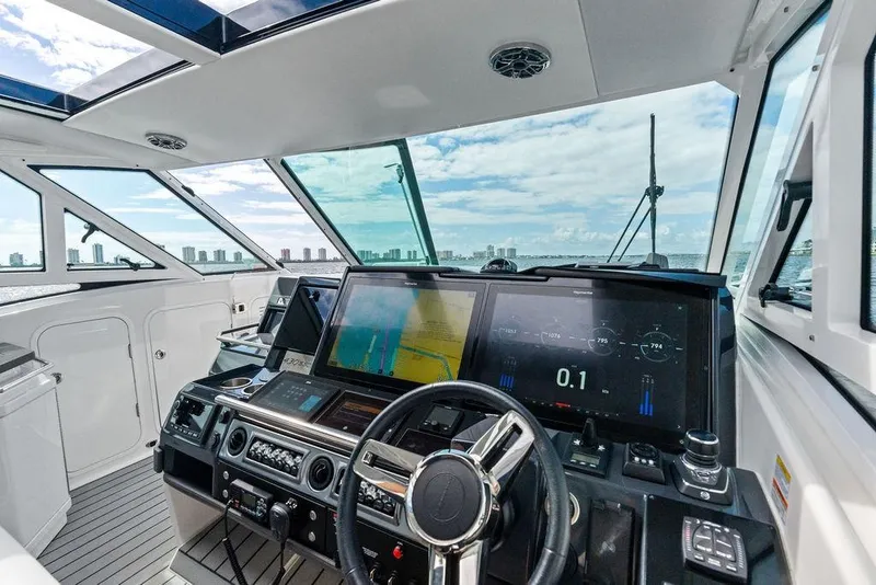 Slide: The Image of 2023 Formula 430 Super Sport Crossover helm with advanced navigation displays and city skyline view. - 43