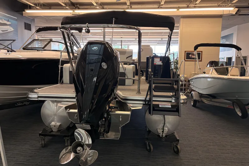 Slide: The Image of 2026 Crest Conquest 250 SLSC pontoon boat displayed in showroom with outboard motor. - 19