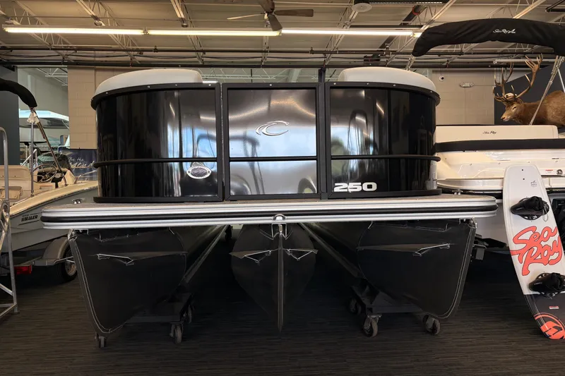 Slide: The Image of 2026 Crest Conquest 250 SLSC pontoon boat displayed indoors, black exterior. - 3