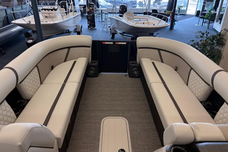 Slide: The Image of 2026 Crest Conquest 250 SLSC pontoon boat interior with luxurious seating in showroom. - 6