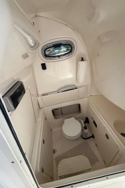 Slide: The Image of 2004 Boston Whaler 270 Outrage boat cabin with compact toilet and window. - 11