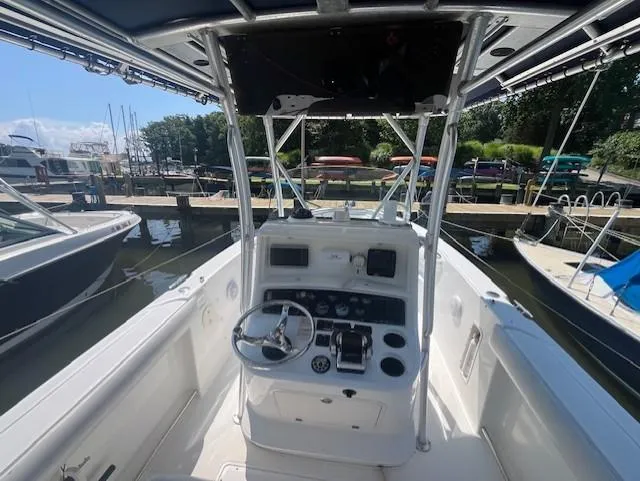 Slide: The Image of 2004 Boston Whaler 270 Outrage boat cockpit with steering wheel and controls at marina. - 7