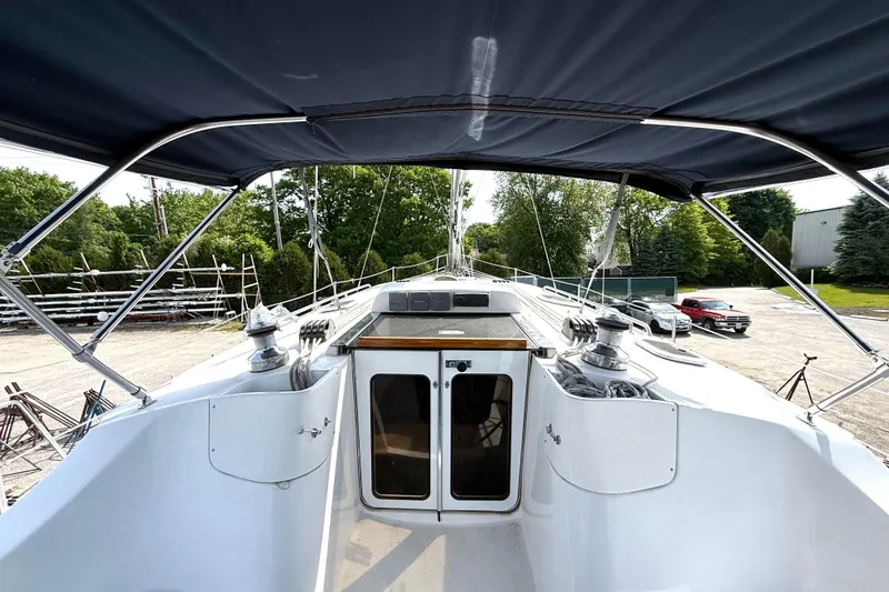 Slide: The Image of 2005 Hunter 41 Deck Salon sailboat cockpit with canopy, winches, and dual doors. - 12