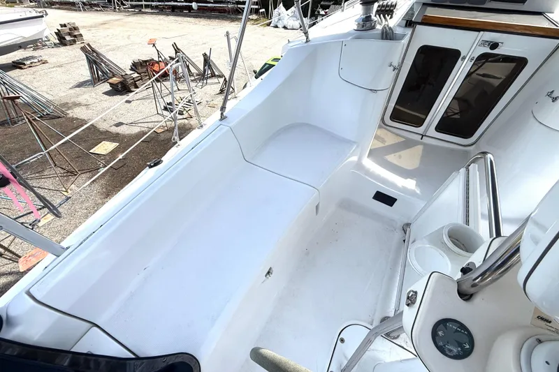 Slide: The Image of 2005 Hunter 41 Deck Salon cockpit with white seating and storage compartments. - 15