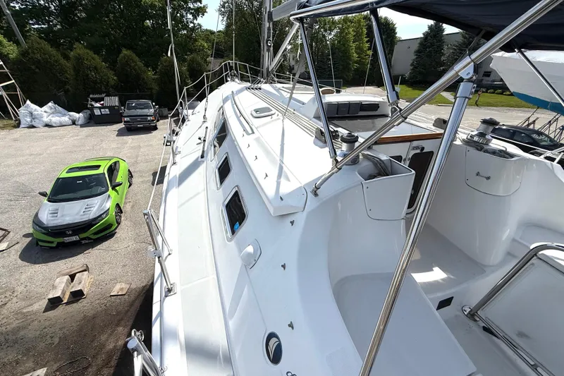 Slide: The Image of 2005 Hunter 41 Deck Salon sailboat on land beside a bright green car. - 16