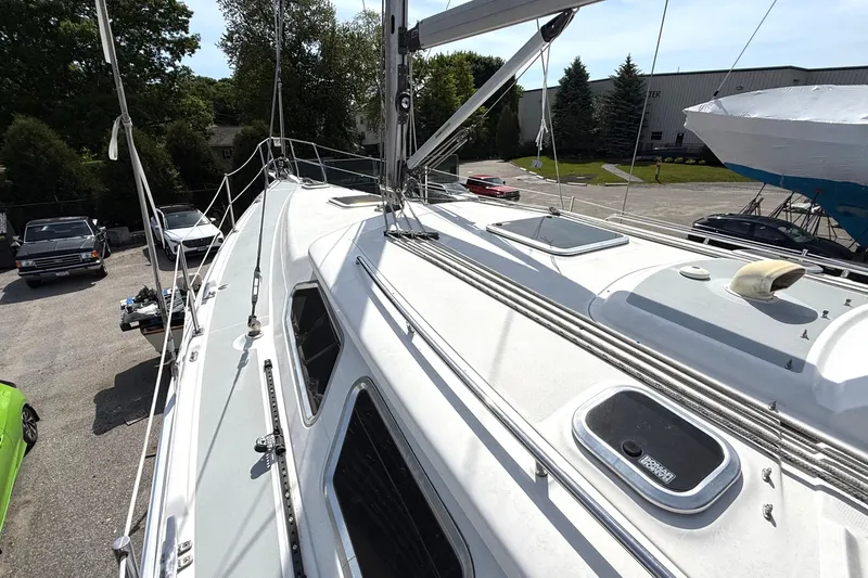 Slide: The Image of 2005 Hunter 41 Deck Salon sailboat on land, showcasing deck and rigging details. - 17