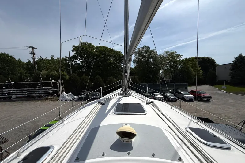 Slide: The Image of 2005 Hunter 41 Deck Salon sailboat deck view with rigging and parked cars. - 18