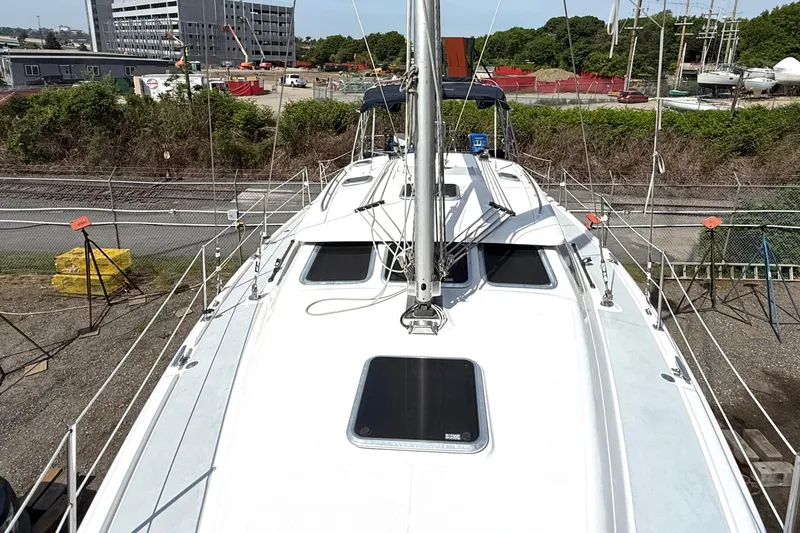 Slide: The Image of 2005 Hunter 41 Deck Salon sailboat on land, surrounded by industrial area and greenery. - 24
