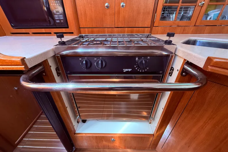 Slide: The Image of 2005 Hunter 41 Deck Salon kitchen with stove, oven, and wooden cabinetry. - 34