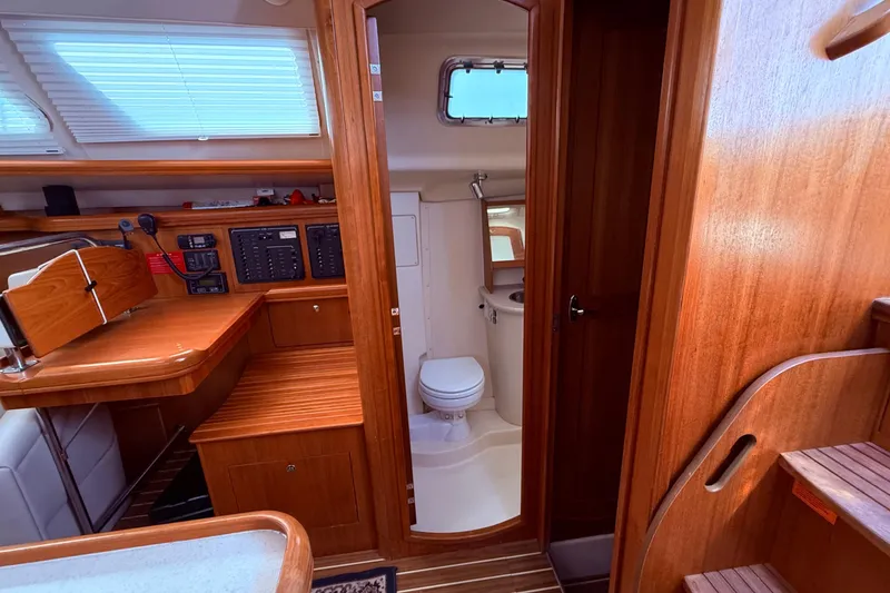 Slide: The Image of Interior of 2005 Hunter 41 Deck Salon yacht with wooden cabinetry and compact bathroom. - 38