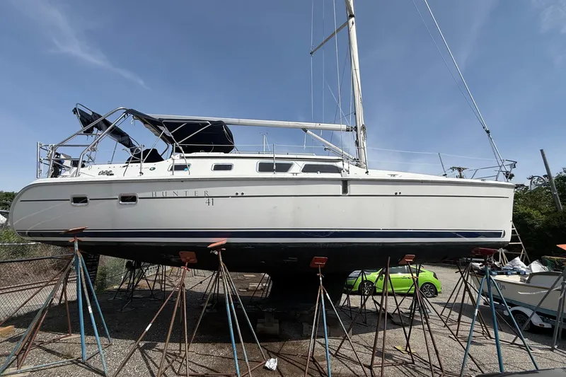 Slide: The Image of 2005 Hunter 41 Deck Salon sailboat on stands, under clear blue sky. - 4