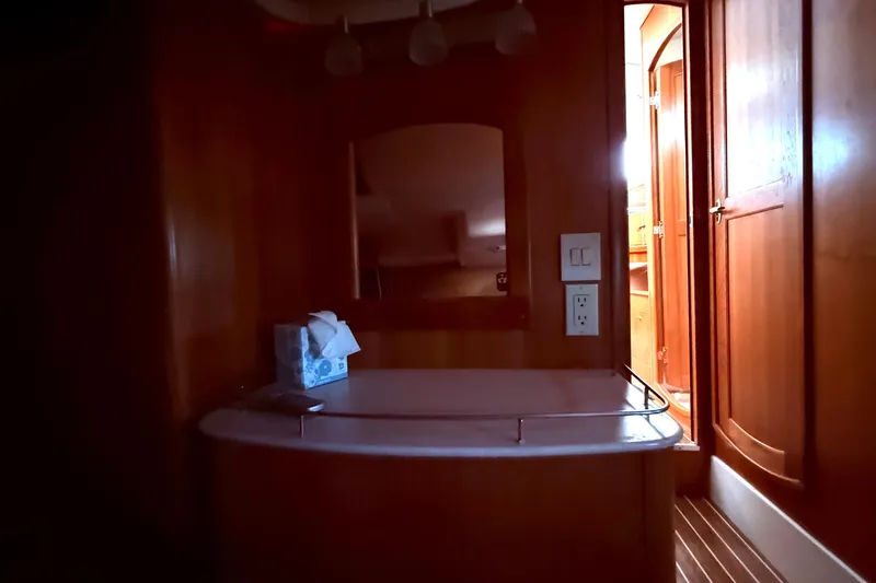 Slide: The Image of Interior of 2005 Hunter 41 Deck Salon yacht, featuring wooden cabinetry and a mirror. - 48