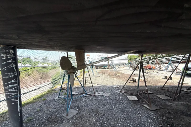 Slide: The Image of 2005 Hunter 41 Deck Salon sailboat under maintenance, showing propeller and supports. - 5