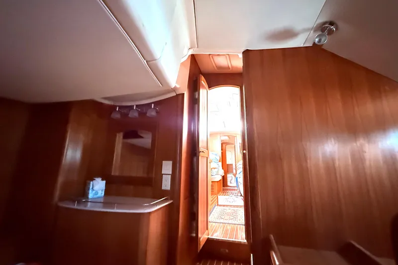 Slide: The Image of Interior view of 2005 Hunter 41 Deck Salon, featuring wooden cabinetry and cozy lighting. - 50