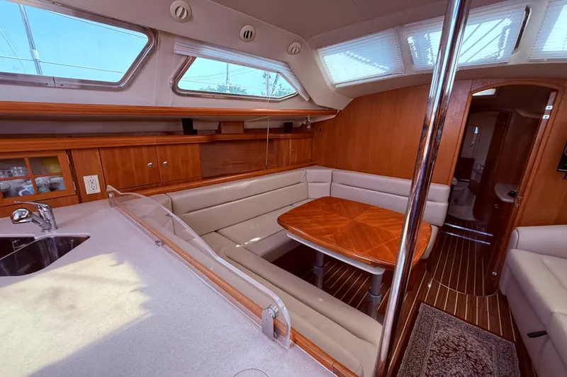Slide: The Image of Interior of 2005 Hunter 41 Deck Salon, featuring a cozy dining area and modern kitchen. - 51