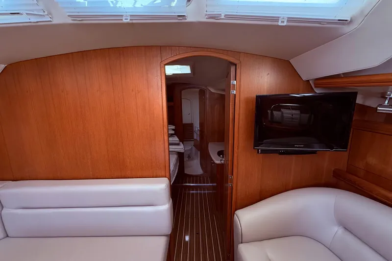 Slide: The Image of Interior of 2005 Hunter 41 Deck Salon with wood paneling, seating, and mounted TV. - 53