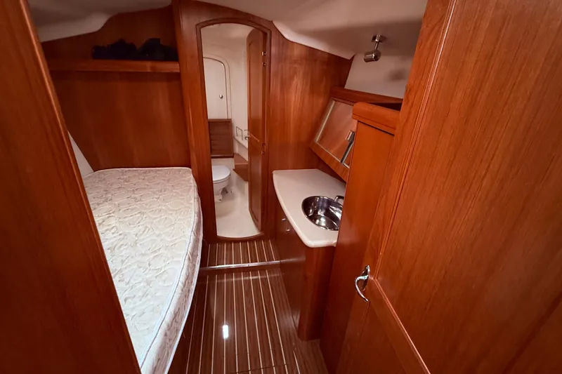 Slide: The Image of Interior of 2005 Hunter 41 Deck Salon yacht with wood finish, bed, and compact bathroom. - 54