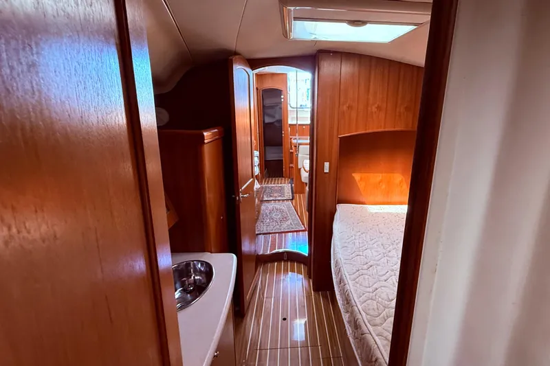 Slide: The Image of Interior of 2005 Hunter 41 Deck Salon yacht, featuring wood paneling and cozy sleeping area. - 59