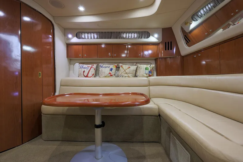 Slide: The Image of Luxurious interior of 2002 Sea Ray 410 Express Cruiser with plush seating and wooden accents. - 10