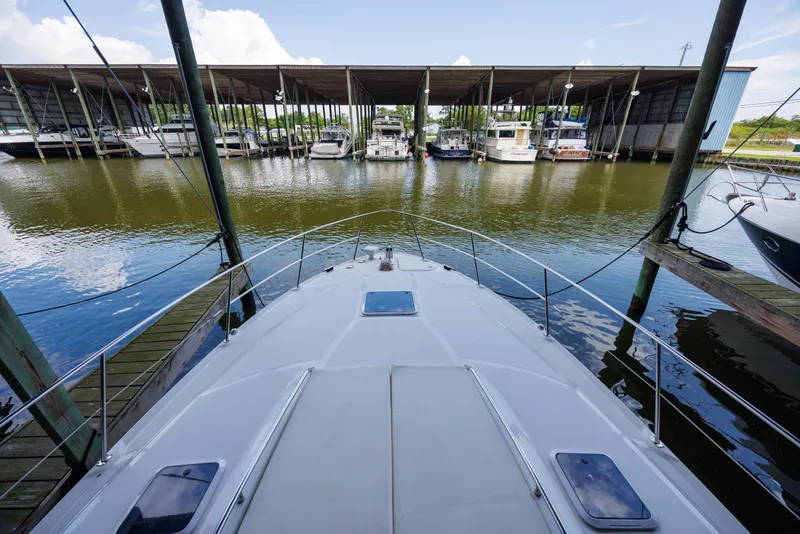 Slide: The Image of 2002 Sea Ray 410 Express Cruiser docked at marina with covered slips. - 17