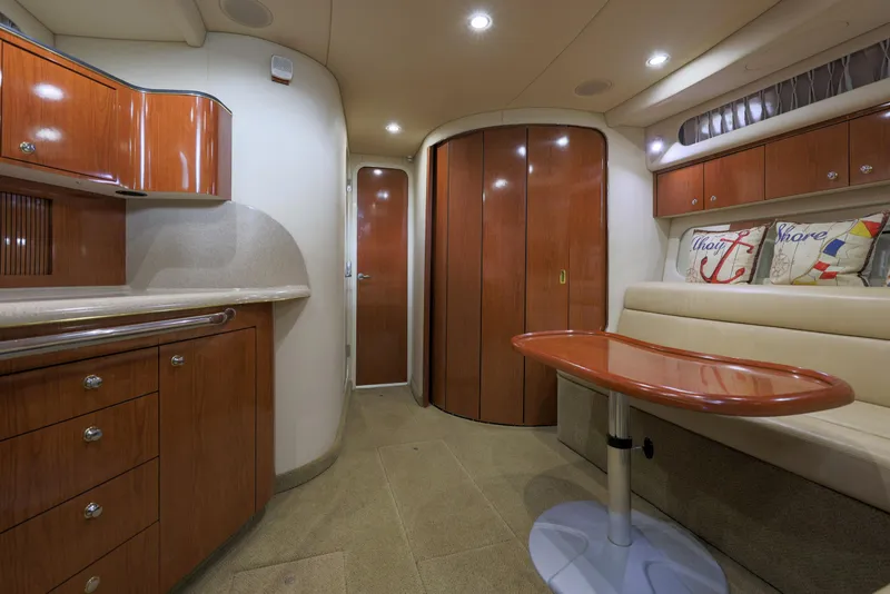 Slide: The Image of Luxurious interior of 2002 Sea Ray 410 Express Cruiser with elegant wood finishes and cozy seating. - 8