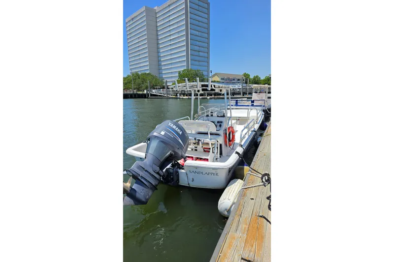 Slide: The Image of 2011 Carolina Skiff 258 DLV boat docked with Yamaha outboard motor. - 12