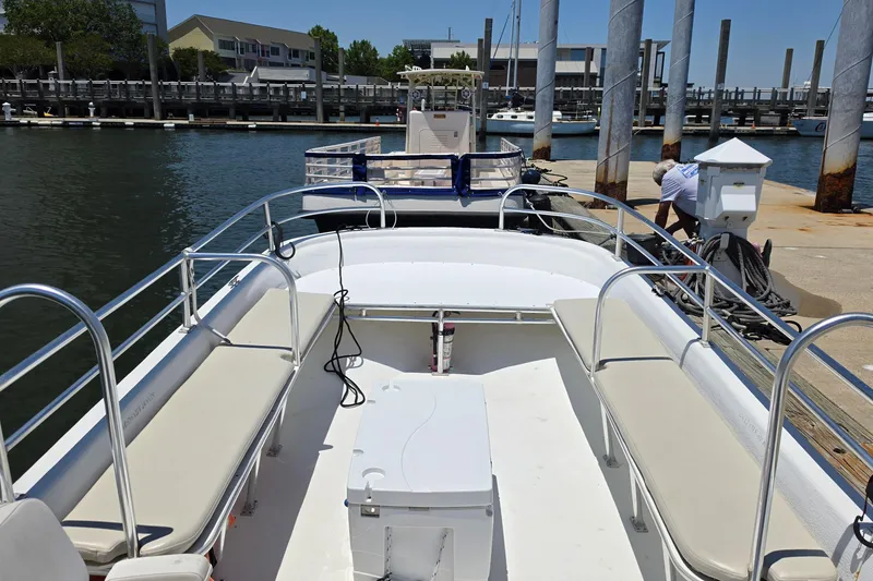 Slide: The Image of 2011 Carolina Skiff 258 DLV boat docked at marina, featuring spacious seating and railing. - 4