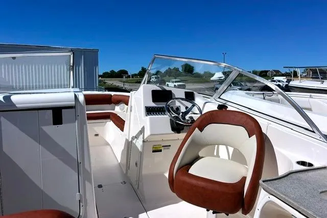 Slide: The Image of 2020 Key West 239 DFS boat interior with brown and white seating, steering wheel, and dashboard. - 15