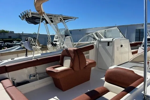 Slide: The Image of 2020 Key West 239 DFS boat interior with brown seating and canopy, docked outdoors. - 5