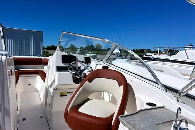 Slide: The Image of 2020 Key West 239 DFS boat interior with brown and white seating under clear blue sky. - 7
