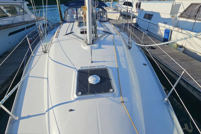 Slide: The Image of 2002 Jeanneau Sun Odyssey 37 sailboat docked, showcasing deck and rigging details. - 10