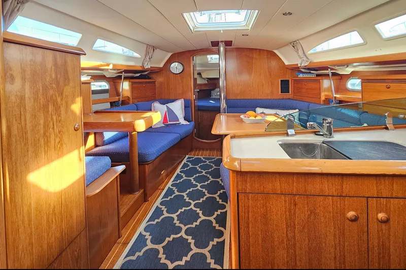 Slide: The Image of Interior of 2002 Jeanneau Sun Odyssey 37 yacht with wooden cabinetry and blue seating. - 13