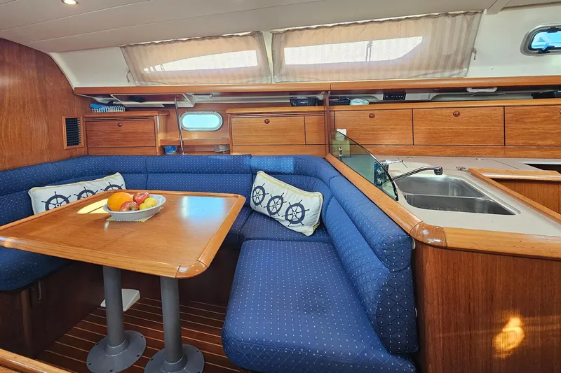Slide: The Image of Interior of 2002 Jeanneau Sun Odyssey 37 yacht with cozy seating and wooden cabinetry. - 19