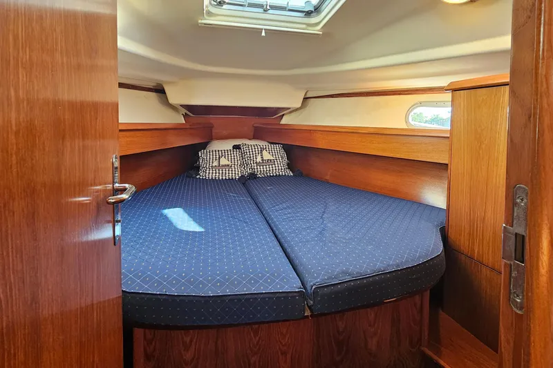 Slide: The Image of Cozy cabin interior of 2002 Jeanneau Sun Odyssey 37 sailboat with blue bedding. - 20
