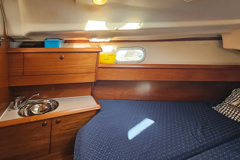 Slide: The Image of Interior cabin of 2002 Jeanneau Sun Odyssey 37 with wooden cabinetry and cozy bedding. - 21
